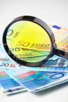 Euro currency under a magnifying glass