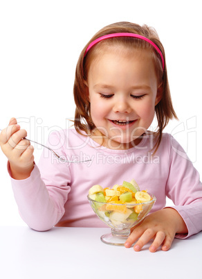 Little girl eats fruit salad