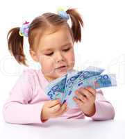 Little girl with few paper euro banknotes