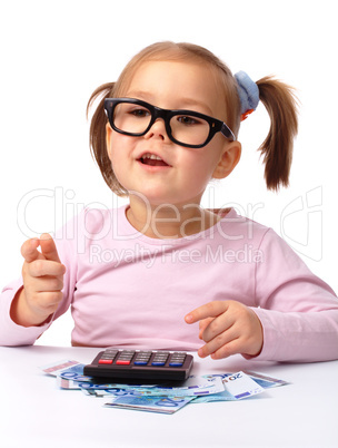 Little girl plays with money