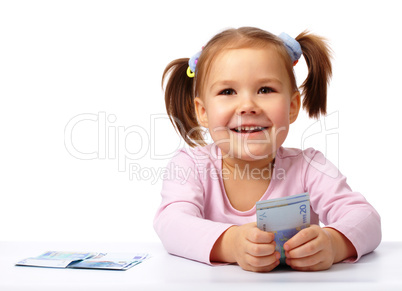 Little girl with few paper euro banknotes