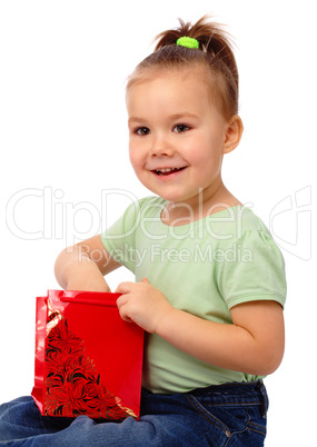 Cute little girl with red shopping bag