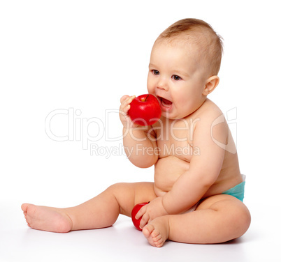 Little child is going to bite red apple