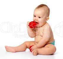 Little child is going to bite red apple