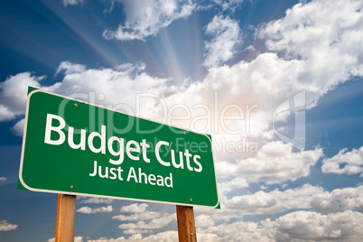 Budget Cuts Green Road Sign and Clouds