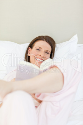 Woman reading a book on her bed