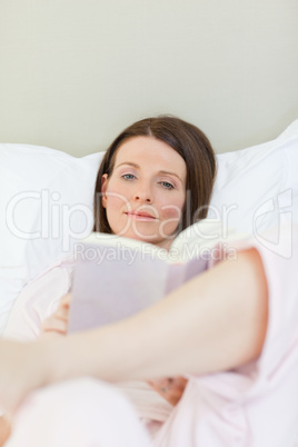 Woman reading a book on her bed