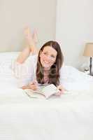 Woman reading a book on her bed