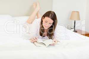 Woman reading a book on her bed