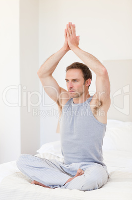 Man practicing yoga on his bed