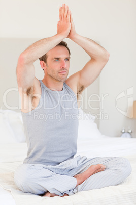 Man practicing yoga on his bed