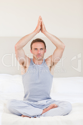 Man practicing yoga on his bed