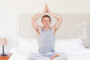 Man practicing yoga on his bed