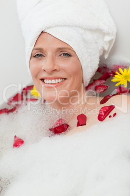 Relaxed woman taking a relaxing bath with a towel on her head