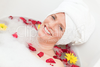 Relaxed woman taking a relaxing bath with a towel on her head