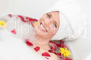 Relaxed woman taking a relaxing bath with a towel on her head