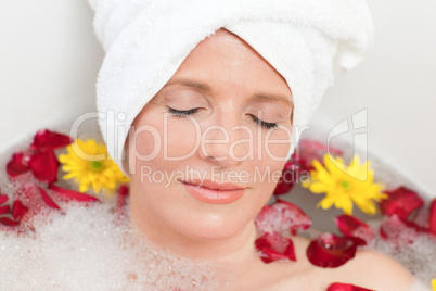 Relaxed woman taking a relaxing bath with a towel on her head