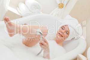 Smiling woman taking a bath with a towel on her head