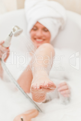 Smiling woman taking a bath with a towel on her head