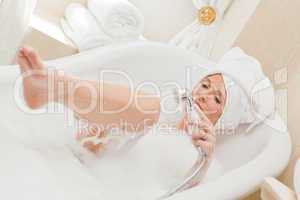 Smiling woman taking a bath with a towel on her head