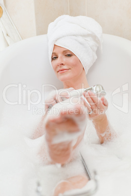 Smiling woman taking a bath with a towel on her head