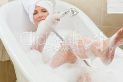 Smiling woman taking a bath with a towel on her head