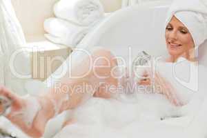 Smiling woman taking a bath with a towel on her head