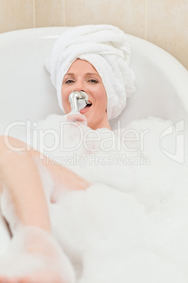 Charming woman taking a bath with a towel on her head