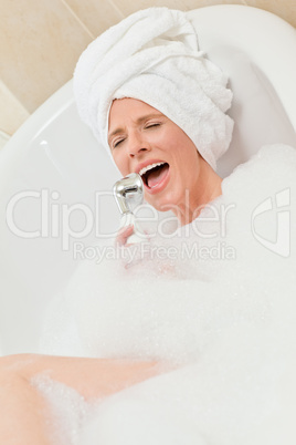 Charming woman taking a bath with a towel on her head