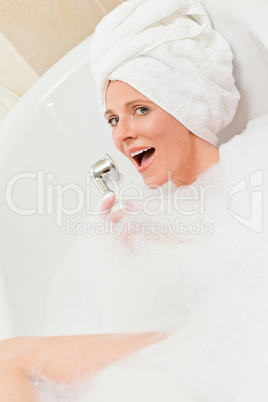 Charming woman taking a bath with a towel on her head