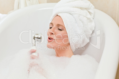 Charming woman taking a bath with a towel on her head