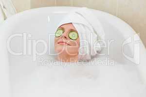 Relaxed woman taking a bath with a towel on her head