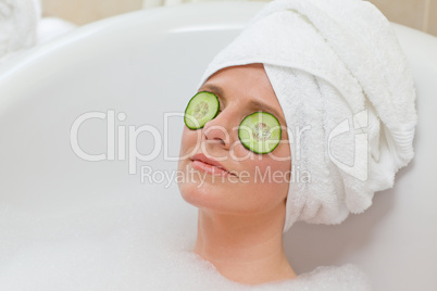 Relaxed woman taking a bath with a towel on her head