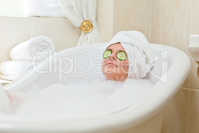 Relaxed woman taking a bath with a towel on her head