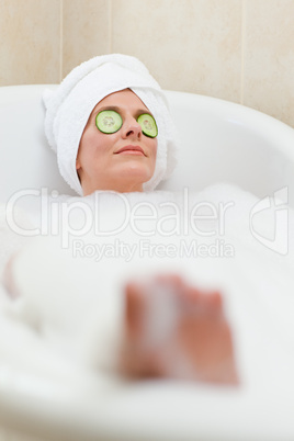 Relaxed woman taking a bath with a towel on her head