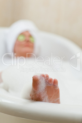 Relaxed woman taking a bath with a towel on her head