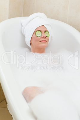 Relaxed woman taking a bath with a towel on her head