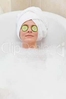 Relaxed woman taking a bath with a towel on her head