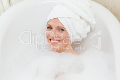 Lovely woman taking a bath with a towel on her head