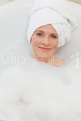 Lovely woman taking a bath with a towel on her head