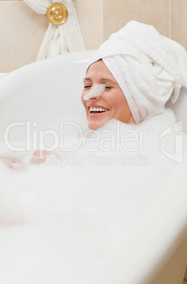 Lovely woman taking a bath with a towel on her head