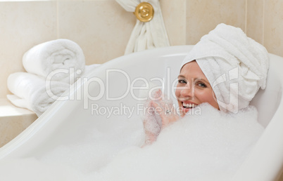 Lovely woman taking a bath with a towel on her head