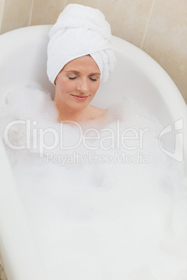 Lovely woman taking a bath with a towel on her head