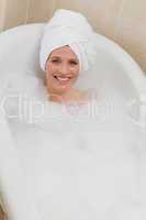 Lovely woman taking a bath with a towel on her head