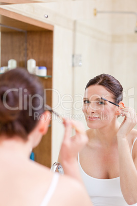 Woman curling her eyelashes