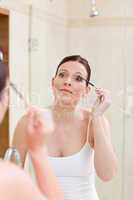 Woman curling her eyelashes