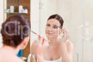 Woman curling her eyelashes