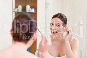 Woman curling her eyelashes