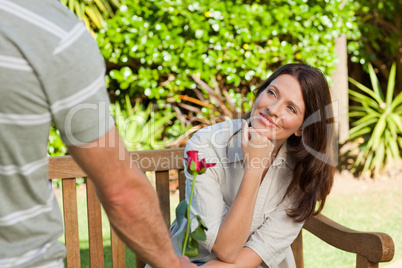 Man offering a rose to his wife