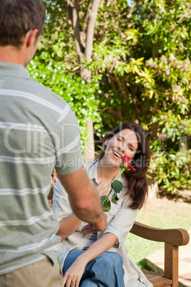 Man offering a rose to his wife